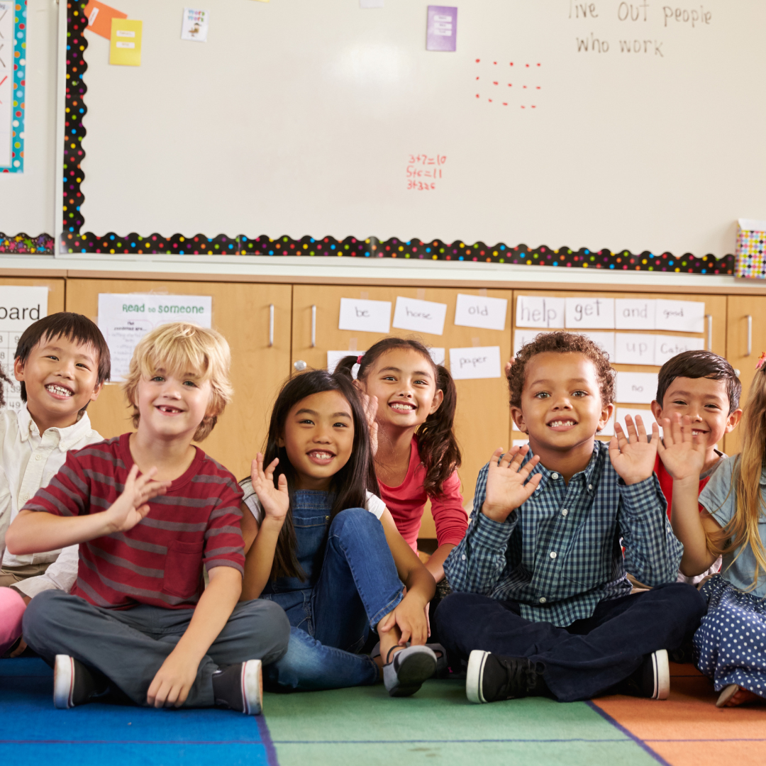 Elementary school kids in school waving